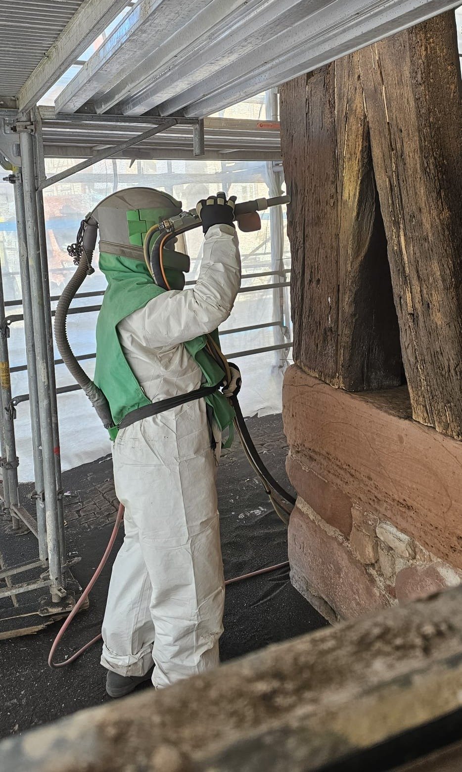 Ralf Rößler beim Strahlen an Fachwerk-Holzbalken